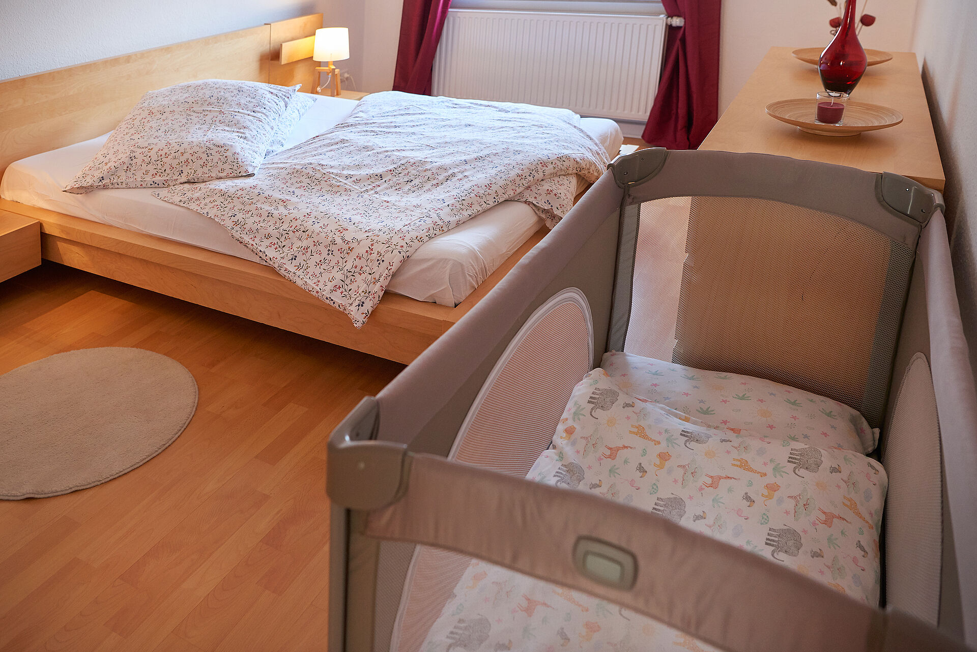 Schlafzimmer mit Kommode, Doppelbett und Kinderbett