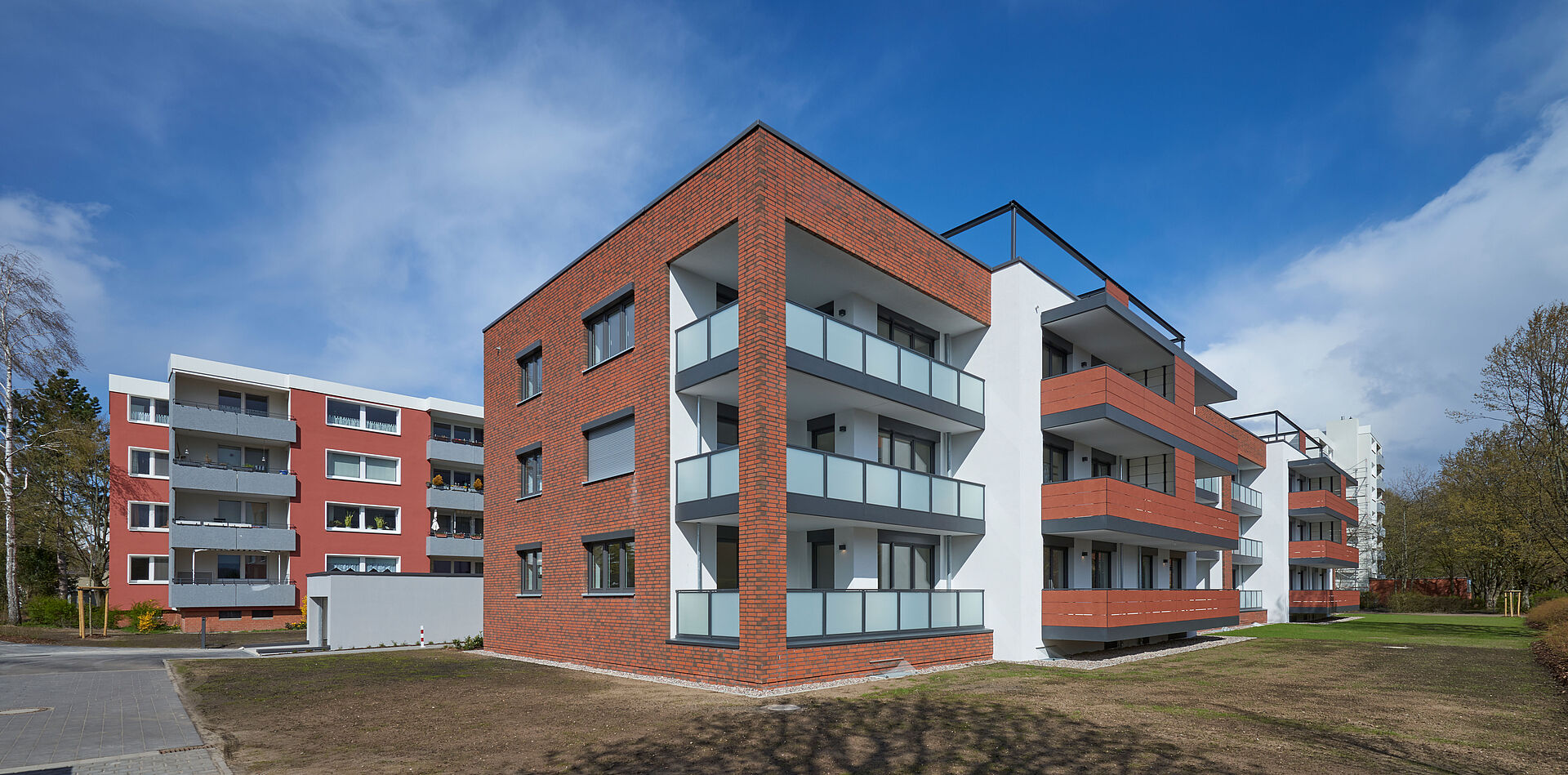 Mehrfamilienhaus mit roter Klinkerfassade und großen Balkonen